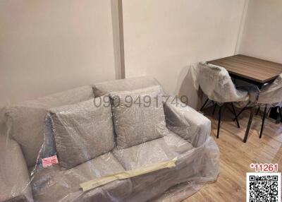 Living room with furniture still wrapped in protective plastic
