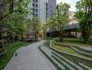 Modern outdoor common area with landscaped garden and walkways in a residential building complex