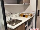 Modern compact kitchen with stainless steel sink and wooden cabinets