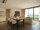 Elegant dining room with adjacent modern kitchen overlooking a scenic view