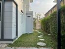 Side yard of a modern home with stepping stones and a water tank