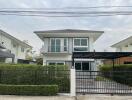 Modern two-story house with balcony and carport