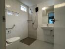 Modern tiled bathroom with walk-in shower, pedestal sink, and large mirror