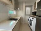 Modern kitchen with stainless steel appliances and washing machine