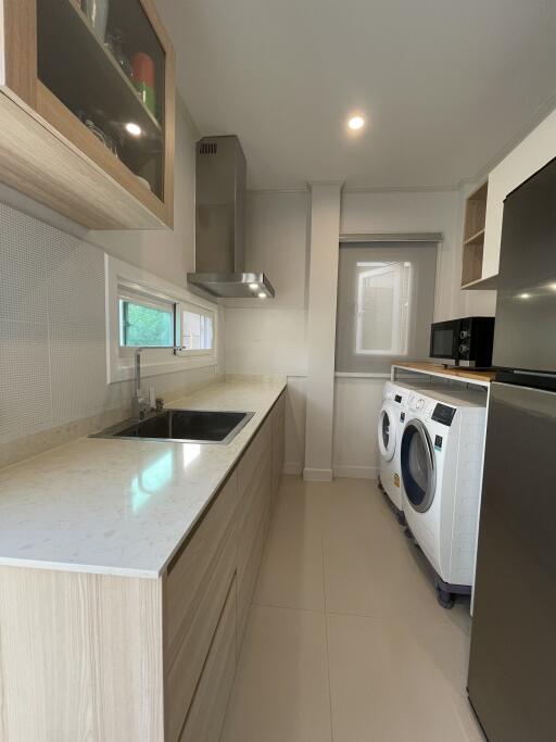 Modern kitchen with stainless steel appliances and washing machine