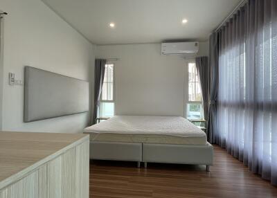 Spacious bedroom with modern design, furnished with a large bed and ample natural light