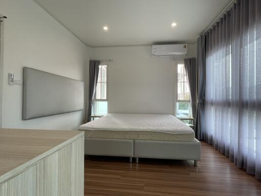 Spacious bedroom with modern design, furnished with a large bed and ample natural light