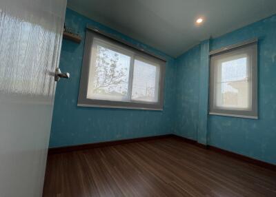 Empty bedroom with blue wallpaper and wooden flooring