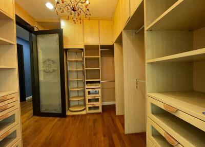 Spacious walk-in closet with wooden cabinets and shelving