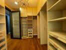 Spacious walk-in closet with wooden cabinets and shelving