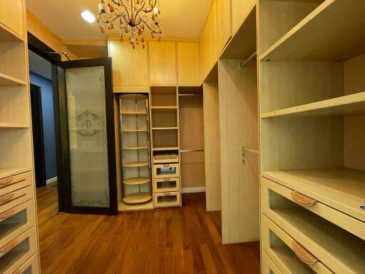 Spacious walk-in closet with wooden cabinets and shelving