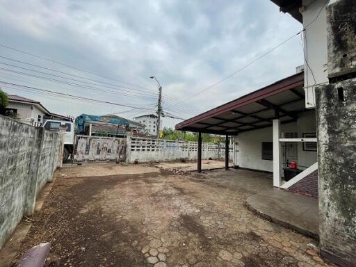 Spacious outdoor area with carport and adjacent open land