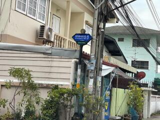 Front view of a multi-level residential building with signage and street view