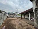 Exterior view of a property with carport and empty lot