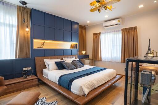 Modern spacious bedroom with queen-sized bed, hardwood floors and stylish interior design