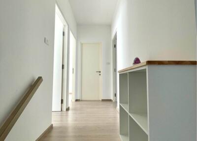 Bright and modern hallway with wooden flooring and white walls
