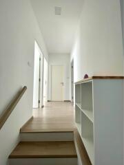 Bright and modern hallway with wooden flooring and white walls