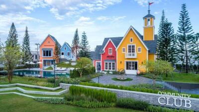 Colorful community club houses with landscaped gardens and a pool