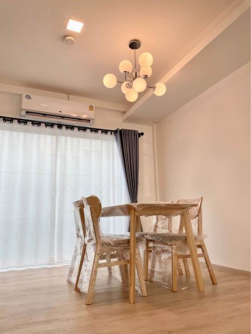 Modern dining space with a window and newly furnished with a table and chairs