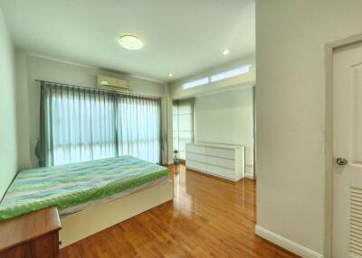 Bright and spacious bedroom with wooden floors and modern amenities