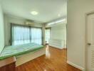 Bright and spacious bedroom with wooden floors and modern amenities