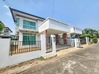 Modern two-story house with large windows and secure gate