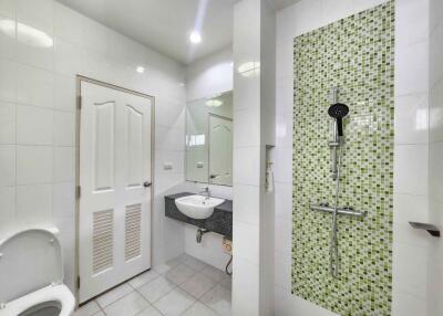 Modern bathroom with green mosaic tiles and shower