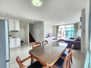 Spacious open plan living room with adjoining dining area and kitchen, featuring modern furnishings and ample natural light