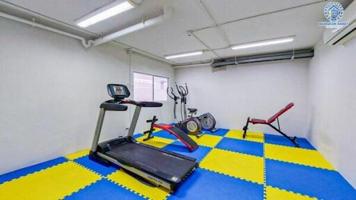 Compact home gym with treadmill, exercise bikes, and weight bench