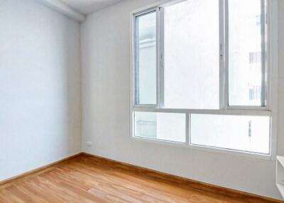 Bright empty bedroom with hardwood floors and large windows