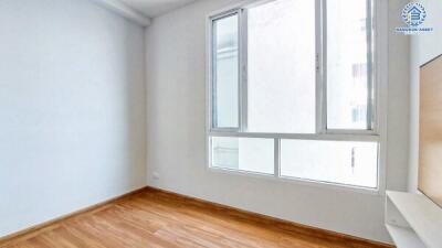 Bright empty bedroom with hardwood floors and large windows