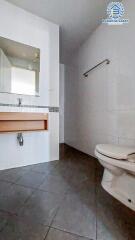 Modern bathroom with white fixtures and wooden counter