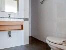 Modern bathroom with white fixtures and wooden counter