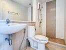 Modern clean bathroom with a wall-mounted sink, toilet, and shower system