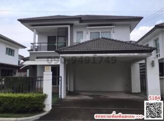 Modern two-story residential house with a balcony and carport