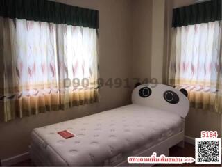 Cozy bedroom with single bed and patterned curtains