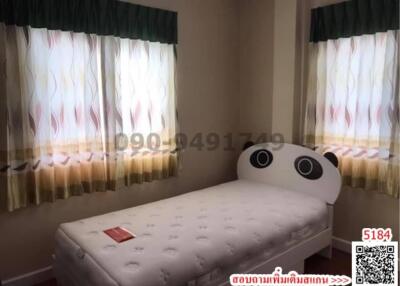 Cozy bedroom with single bed and patterned curtains