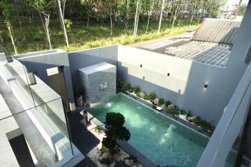 Elevated view of a modern house with a private pool and garden