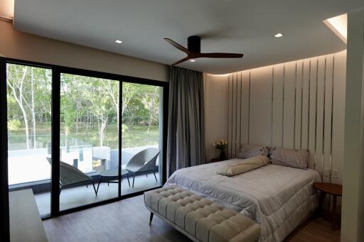 Spacious bedroom with large windows and natural surroundings