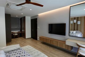 Modern bedroom interior with mounted television and wooden accents