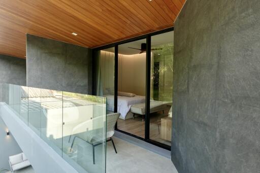 Modern bedroom with large sliding glass doors and a view of a balcony