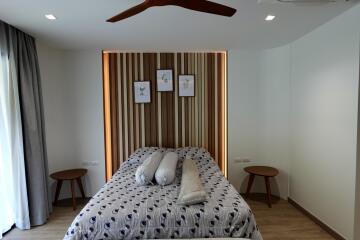 Modern bedroom with wooden accent wall and comfortable bedding