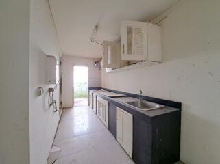 Compact kitchen space with white cabinetry and natural light