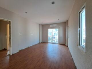 Spacious empty living room with hardwood floors and natural light