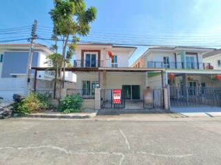 Front view of a two-story residential house with a gated entrance