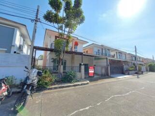 Suburban neighborhood with a row of townhouses and a clear blue sky