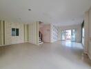 Spacious living room with natural light and staircase