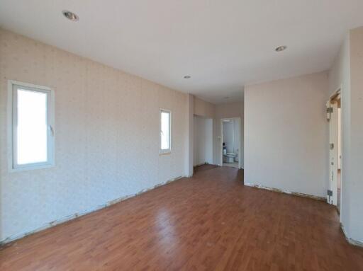 Spacious unfurnished room with hardwood floors and abundant natural light