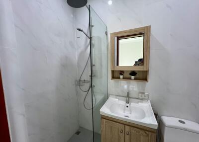 Modern bathroom with a walk-in shower, wall-mounted sink and toilet