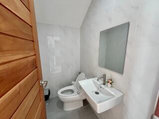 Modern bathroom with marble tiles and wooden door